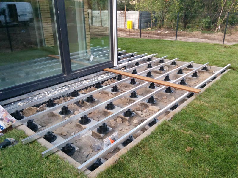 Aluminiumbalken auf der Unterkonstruktion der Terrasse auf dem Boden
