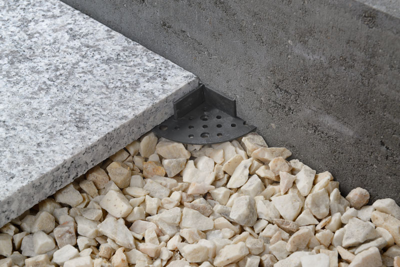 support pads on gravel under paver near wall